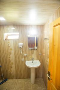 库塔伊西Eco Cottage的一间带水槽的浴室和墙上的电视