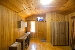 库塔伊西Eco Cottage的木制客房配有桌子和冰箱。