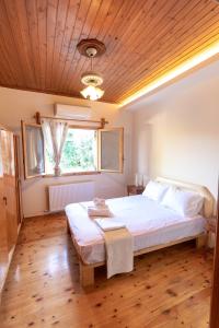 阿特米达Villa Artemis Leto的一间卧室设有一张带木制天花板的大床