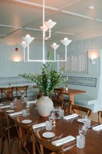 汉普顿贝斯Canoe Place Inn & Cottages的一间用餐室,配有一张桌子和花瓶