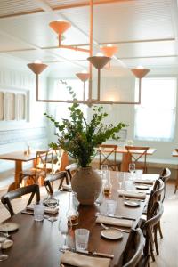 汉普顿贝斯Canoe Place Inn & Cottages的一间用餐室,配有一张桌子和花瓶
