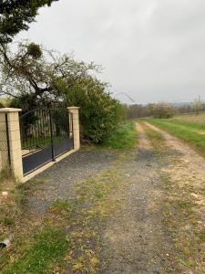 Mareuil-sur-Cherloge de la Besnardière的田野旁土路的大门