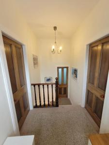 莫法特Character cottage in centre of Moffat的走廊设有两扇木门和吊灯