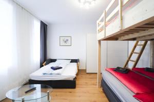 维也纳CozyNite Premium Apartment Schönbrunn 1的卧室配有两张双层床和玻璃桌