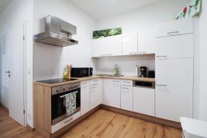 维也纳CozyNite Premium Apartment Schönbrunn 1的厨房配有白色橱柜和炉灶。