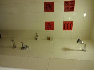 海得拉巴海得拉巴高科技城红狐狸酒店的浴室设有2个水龙头和白色瓷砖地板。