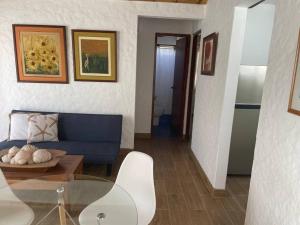 帕拉卡斯Departamento pequeño 2 BR en zona ideal de Paracas的客厅配有蓝色的沙发和桌子