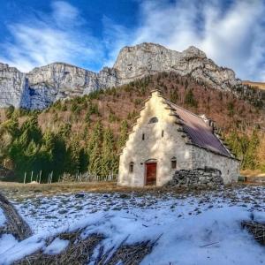 SovramonteTiny House Dolomiti的一座古老的石头建筑,背景是一座山