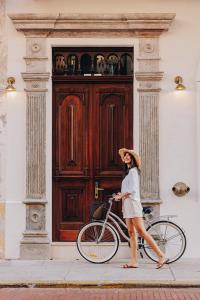 巴拿马城Amarla Boutique Hotel Casco Viejo的一位妇女骑着自行车在建筑物前行走