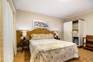 坎波斯杜若尔当波萨达意大利亚埃勒甘扎旅馆的一间卧室配有一张床、两张桌子和一个衣柜