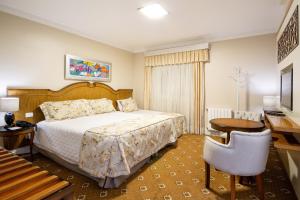 坎波斯杜若尔当波萨达意大利亚埃勒甘扎旅馆的一间卧室配有一张床、一张桌子和一张书桌
