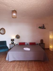 TenteniguadaSuite Zen y Cueva Refugio的一间卧室配有一张床和一张蓝色椅子