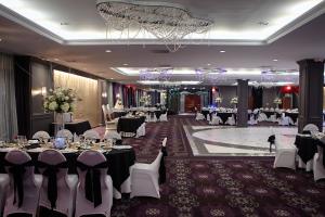扬克斯皇家丽晶酒店的宴会厅配有桌椅和吊灯