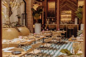 巴拿马城Amarla Boutique Hotel Casco Viejo的一间带桌椅的餐厅和一间酒吧