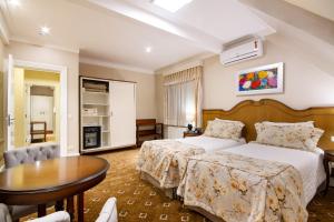 坎波斯杜若尔当波萨达意大利亚埃勒甘扎旅馆的酒店客房配有一张床铺和一张桌子。