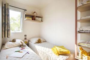 维琪奥港Camping La Baie des Voiles的带窗户的客房内设有两张单人床。