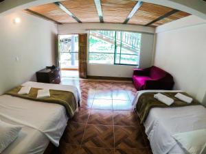 San CarlosFINCA HOTEL CURIBAY的一间设有两张床和椅子的房间