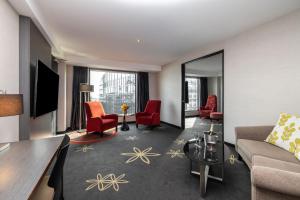 奥克兰SkyCity Hotel Auckland的带沙发和红色椅子的客厅