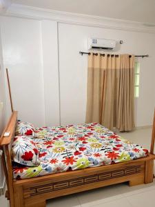 科托努Peaceful Stay 1SR的一间卧室配有一张带花卉图案的毯子的床