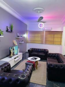 科托努Peaceful Stay 1SR的客厅配有两张真皮沙发和一台电视机