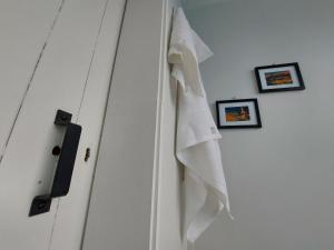泰哈皮DuxHouse BnB的白色的门,上面挂着毛巾