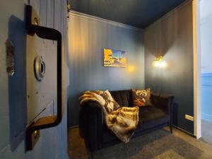 泰哈皮DuxHouse BnB的客厅配有一张沙发,上面有一条毯子