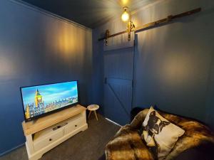 泰哈皮DuxHouse BnB的客厅配有平面电视和沙发。