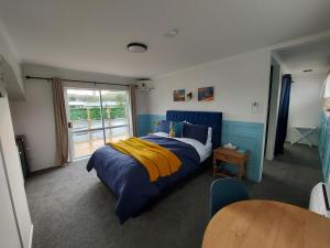 泰哈皮DuxHouse BnB的一间卧室配有蓝色和黄色的床和一张桌子
