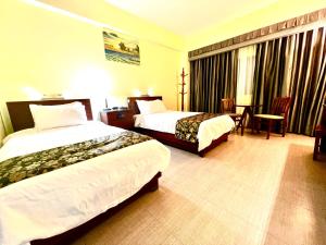 加拉班塞班岛塞伦蒂酒店的酒店客房设有两张床和一张桌子。