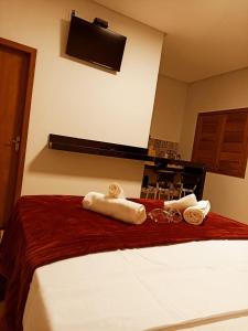 皮雷诺波利斯Chalés por do sol的酒店客房,配有带毛巾的床
