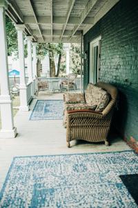 GrotonBenn Conger Inn的坐在房子门廊上的藤椅