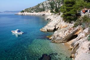 特斯特诺Apartments with WiFi Trsteno, Dubrovnik - 4746的岩石海岸边的水中的小船