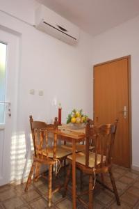 特斯特诺Apartments with WiFi Trsteno, Dubrovnik - 8738的一张带椅子的木桌和一碗水果