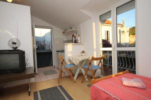 特斯特诺Apartments with a parking space Trsteno, Dubrovnik - 8594的一个带桌子和电视的小客厅