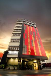 乔治市CitiVilla Penang的一座高大的建筑,上面有红色和橙色的油漆