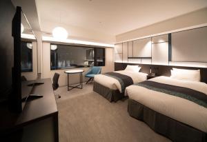大阪Hotel Vischio Osaka-JR Hotel Group的酒店客房配有两张床和一张书桌