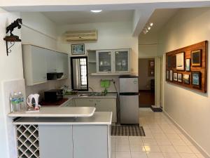 波德申Sevenseas Marina Crescent的厨房配有白色橱柜和白色冰箱。