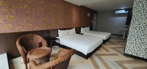 台北喜园旅店的酒店客房,配有两张床和两把椅子
