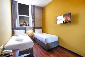 乔治市CitiVilla Penang的客房设有两张床和一台墙上的电视。