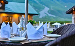 索纳马格Arco Hotels & Resorts sonamarg的一张桌子,上面有白色的餐巾纸和盘子