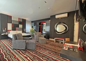 马卡萨Swiss-Belcourt Makassar的酒店客房,配有床和镜子