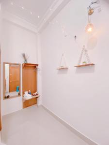 大叻Lantana Homestay的一间设有白色墙壁、镜子和架子的房间