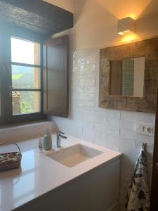 PiluPeta Casa de Aldea的白色的浴室设有水槽和窗户。
