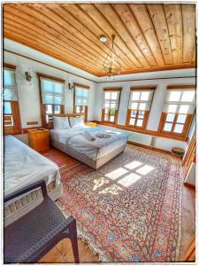 番红花城Muhsin Bey Konağı的一间大卧室,配有两张床和地毯