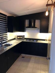 拉瓦尔品第Fully Luxurious Entire Villa Vacation Home In Bahria Town Phase 8的厨房配有黑色橱柜和炉灶烤箱。