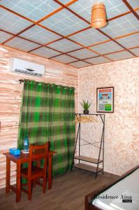 Abomey-CalaviRESIDENCE AINA的配有桌子和绿帘的房间