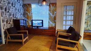 SäkyläPunavilla majoitus TASANKO的客厅配有两把椅子、电视和窗户