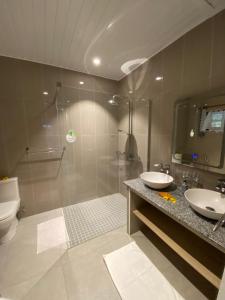 普拉兰多尔度假屋的带淋浴、两个盥洗盆和卫生间的浴室