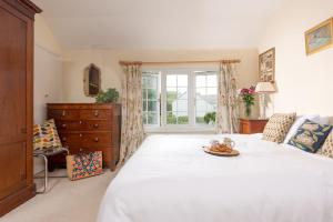GwithianPump Cottage and Annexe, Gwithian的卧室设有一张白色大床和一扇窗户。