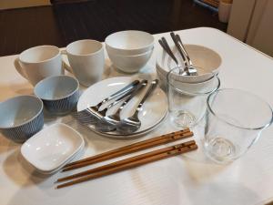 京都龍馬坂荘：1日1組限定・東山清水のてっぺんの小さなお宿、わんこと一緒に。的一张带筷子、盘子和眼镜的白桌